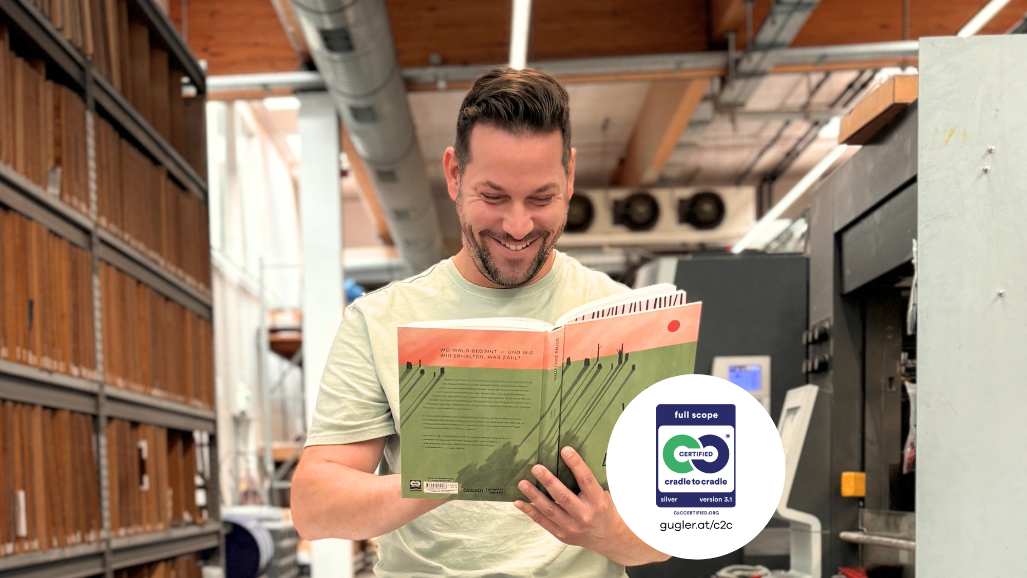 Mitarbeiter von gugler DruckSinn liest ein Cradle to Cradle Certified® Buch in der Druckproduktion. Druckerei für Cradle to Cradle Certified® Druckprodukte auf Silber- und Gold-Niveau